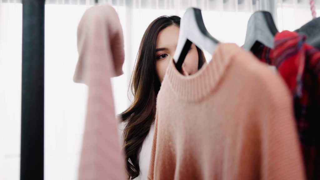 Home wardrobe or clothing shop changing room. Asian young woman